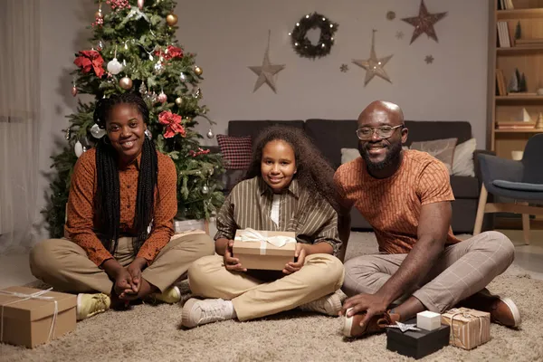 Hedendaagse jonge familie van ouders en leuke dochter met geschenken — Stockfoto