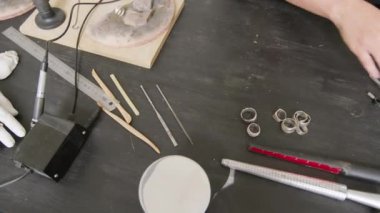 Tepedeki görüntüde tanınmayan bir kuyumcunun tezgahındaki aletleri düzenlerken çekilmiş görüntüler var.