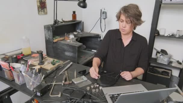 Pan Van Vrouwelijke Juwelier Zit Aan Tafel Weegt Metalen Ring — Stockvideo