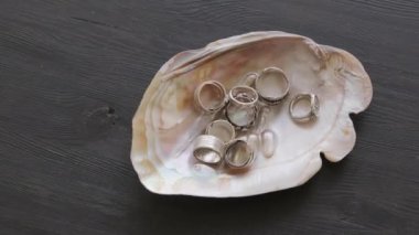 Kuyumcunun üst görüntüsü. Çalışmalarını sergilerken deniz kabuğuna metal yüzük takıyor.