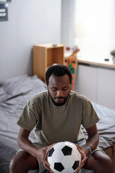 Young serious African man looking at soccer ball — Stock Photo, Image