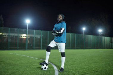 Genç başarılı futbolcu ya da antrenör çimlerin üzerinde duruyor.