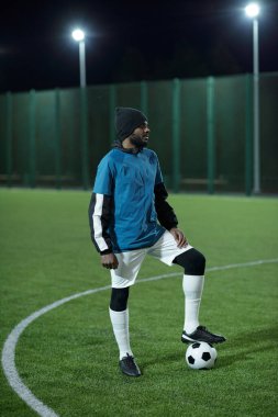 Yeşil sahada üniformalı genç profesyonel futbolcu