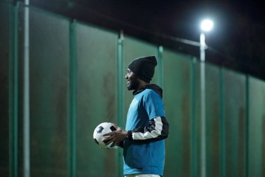 Stadyumda futbol antrenmanı yapan mutlu genç futbolcu.