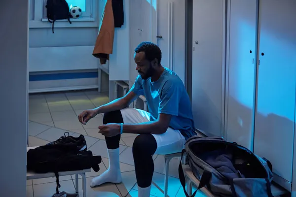 Jovem jogador de futebol vai colocar seus esportes-sapatos — Fotografia de Stock