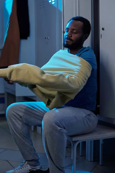 Bearded African sportsman putting on sweatshirt — Stock Photo, Image