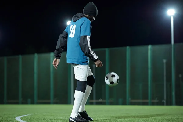Молодий чорношкірий у професійній футбольній формі грає на полі — стокове фото