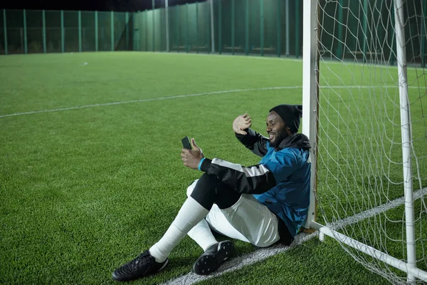 Futbolista feliz saludando la mano a alguien en la pantalla del teléfono inteligente — Foto de Stock