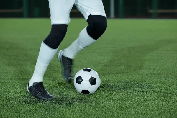 Молодой активный футболист собирается пнуть футбольный мяч — стоковое фото