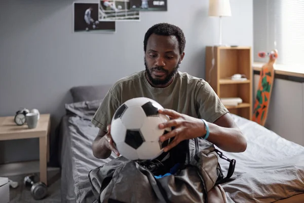年轻的非洲足球运动员把球装进袋子里 — 图库照片