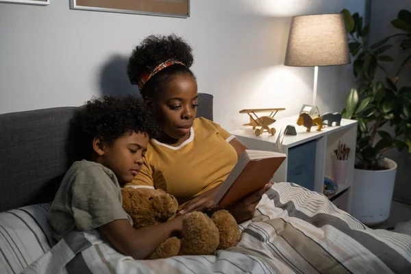 Jonge moeder leest aan vermoeide zoon — Stockfoto