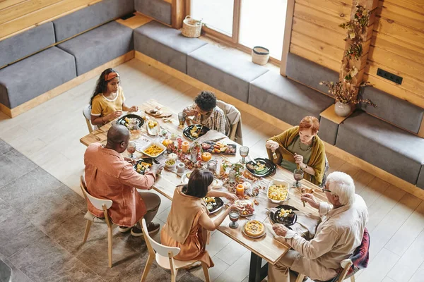 Велика сім'я з шести, які їдять за столом, подається зі святковою їжею — стокове фото