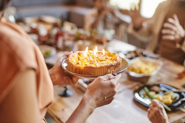 Руки молодої жінки тримають тарілку з домашнім тортом на день народження — стокове фото