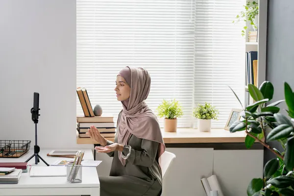 Joven profesor confiado en hijab mirando en la cámara del teléfono inteligente —  Fotos de Stock