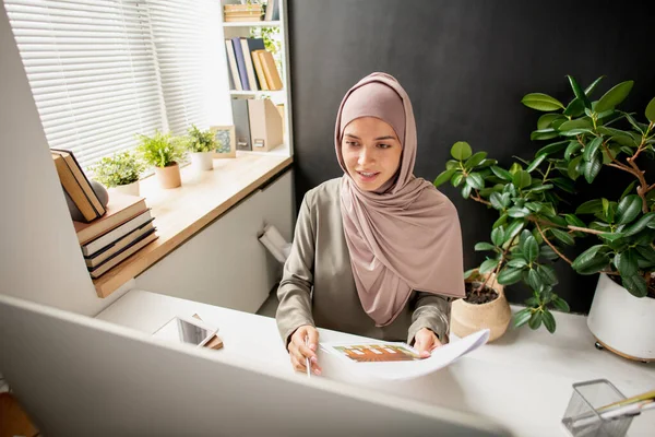 Joven profesor exitoso en hijab mirando la pantalla de la computadora durante la lección en línea —  Fotos de Stock