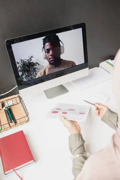 Africano chico en la pantalla de la computadora mirando profesor explicando datos en papel —  Fotos de Stock