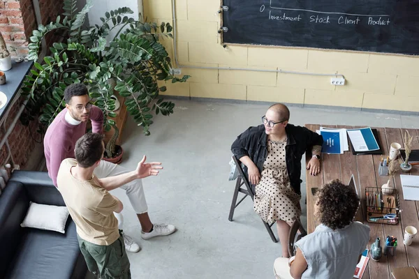 Quatro jovens economistas contemporâneos discutindo as últimas notícias financeiras — Fotografia de Stock