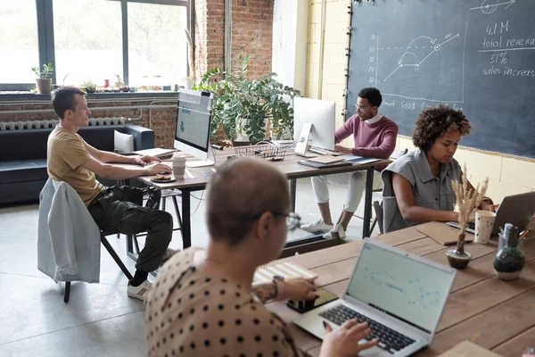 Grupo de jóvenes economistas contemporáneos que trabajan frente a las computadoras —  Fotos de Stock