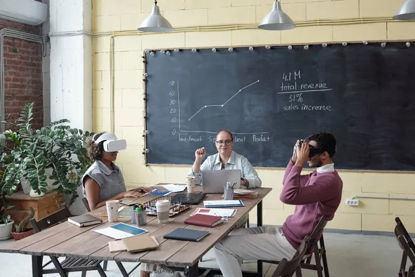 Jeune femme d'affaires assise entre deux collègues dans des casques vr — Photo