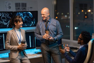 İçki içen üç mutlu iş arkadaşı çalışma ortamında tartışıyorlar.