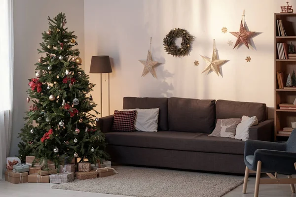 Espaçoso quarto doméstico com sofá, lâmpada, poltrona e árvore de xmas — Fotografia de Stock