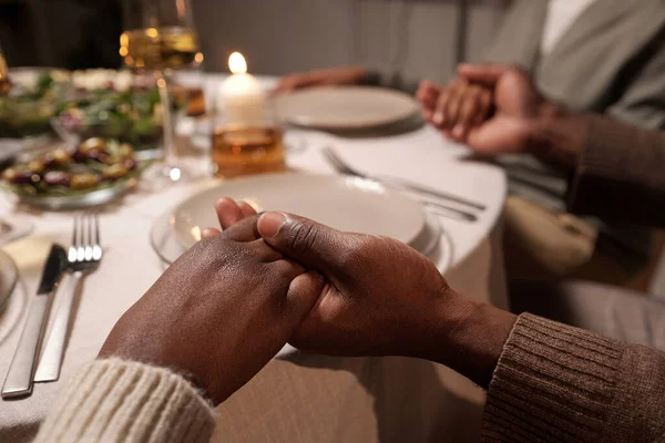 Handen van jong Afrikaans paar tijdens het bidden door feestelijke tafel — Stockfoto