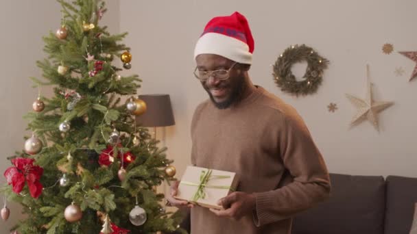 Retrato Homem Afro Americano Feliz Chapéu Santa Segurando Presente Sorrindo — Vídeo de Stock