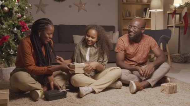 中镜头的快乐的非洲裔美国人家庭在舒适的客厅里打开圣诞礼物 装饰着节日的装饰品 — 图库视频影像