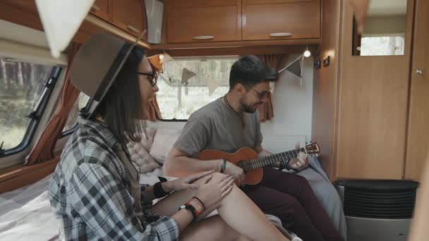 Vista Lateral Joven Feliz Sentada Cama Acogedora Caravana Riendo Mientras — Vídeo de stock