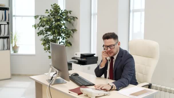 Erkek Yöneticinin Ofis Masasında Oturup Telefon Görüşmesi Yaptığı Orta Boy — Stok video