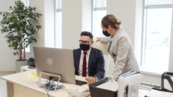 跟踪穿着西装和面罩的商人和女商人在电脑屏幕上讨论办公室工作的照片 — 图库视频影像