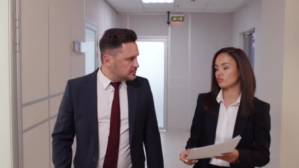 オフィスビルの廊下を歩き 文書を議論するスーツのビジネスマンやビジネスマンの撮影を追跡 — ストック動画
