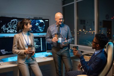 İş yerinde içki içip sohbet eden üç mutlu meslektaş.