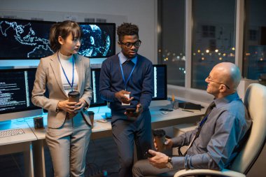 Akıllı telefonları ve içkileri olan iki işadamı çalışma noktalarını tartışıyor.