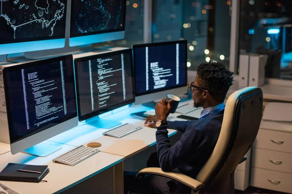 Молодий африканський програміст з написом дивиться на закодовані дані на екрані комп "ютера. — стокове фото