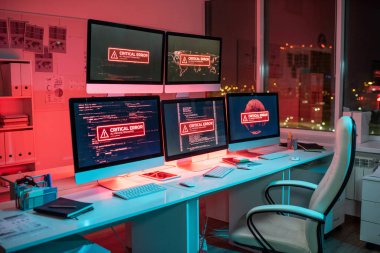 Kritik hata bildiren birkaç bilgisayar ekranı olan boş ofis