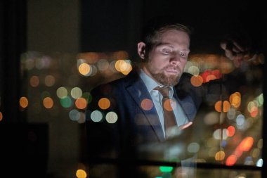 Ofisinde akıllı telefon mesajı olan ciddi bir iş adamı.