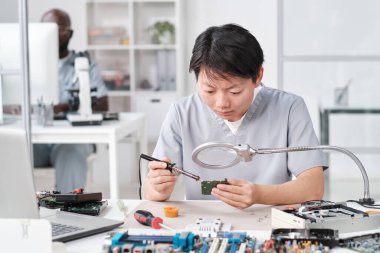 Üniformalı Asyalı kadın lehimleme devresi