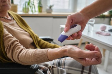 Hasta sıcaklığını ölçen hemşire.