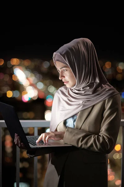 Jonge moslim zakenvrouw in hijab op zoek naar laptop scherm — Stockfoto