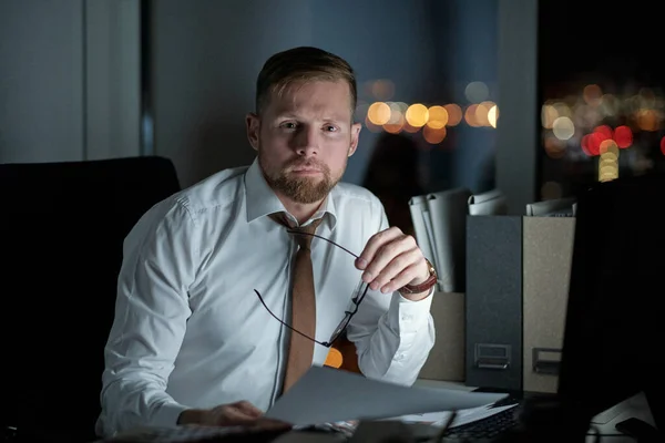 Broker fiducioso con carta guardando la fotocamera mentre si lavora in ufficio — Foto Stock