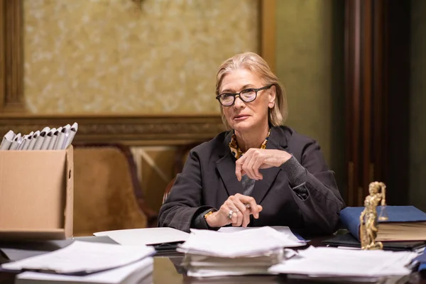 Hedendaagse advocaat in brillen en formele kledij zittend op de werkplek — Stockfoto