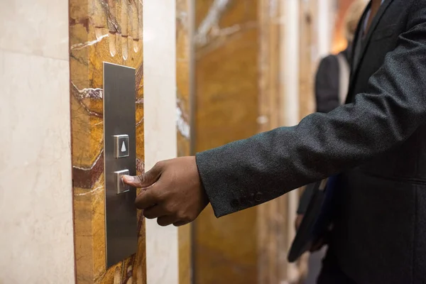 Main de jeune homme d'affaires africain appuyant sur le bouton pour appeler l'ascenseur — Photo