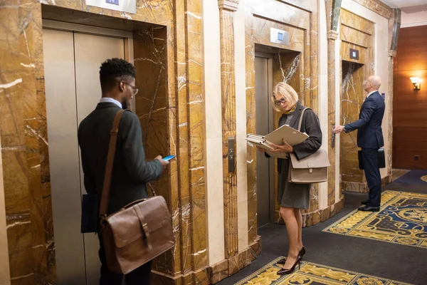 Två interkulturella advokater står i korridoren i businesscenter — Stockfoto