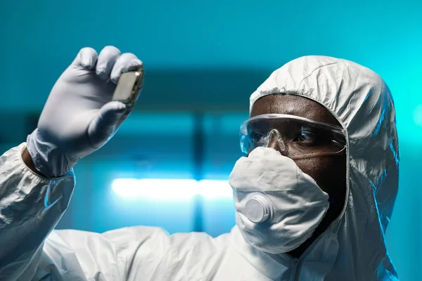 Luva cientista africano em macacões segurando microchip — Fotografia de Stock