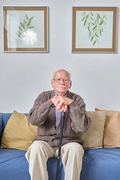 Ηλικιωμένος αναπαύεται στον καναπέ — Φωτογραφία Αρχείου