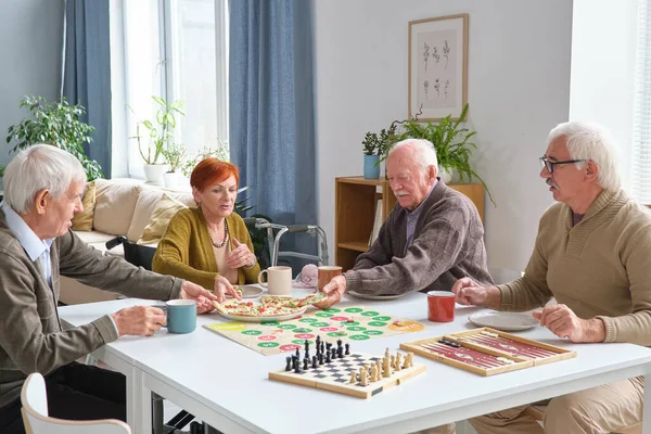 Senior people having a snack during game — Stock Photo, Image