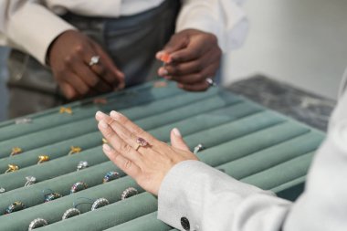 Değerli taşla yüzük takmaya çalışan kadın müşterinin eli