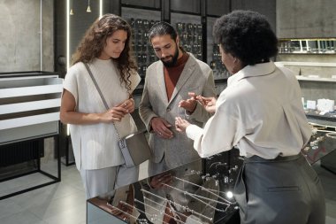 Genç Afrikalı mağaza asistanı yeni mücevher seçmede müşterilere yardım ediyor