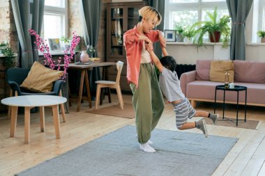 Küçük oğlunu döndüren genç ve güzel bir kadın.